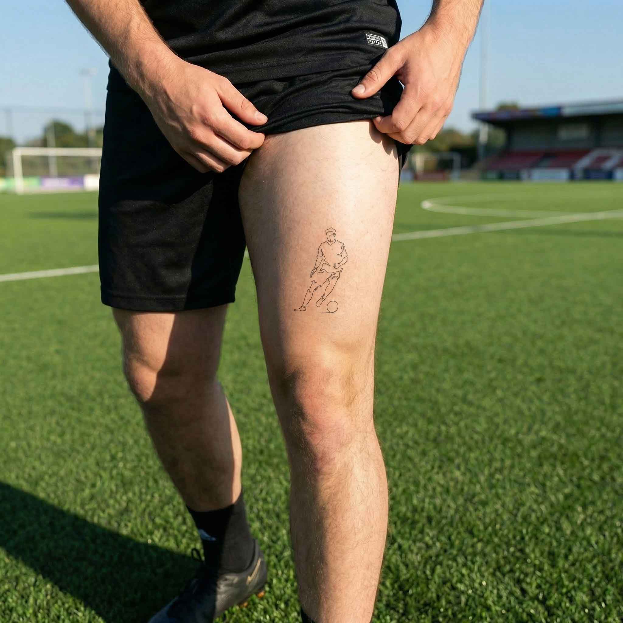 Fine line soccer player tattoo worn on thigh with dribbling motion