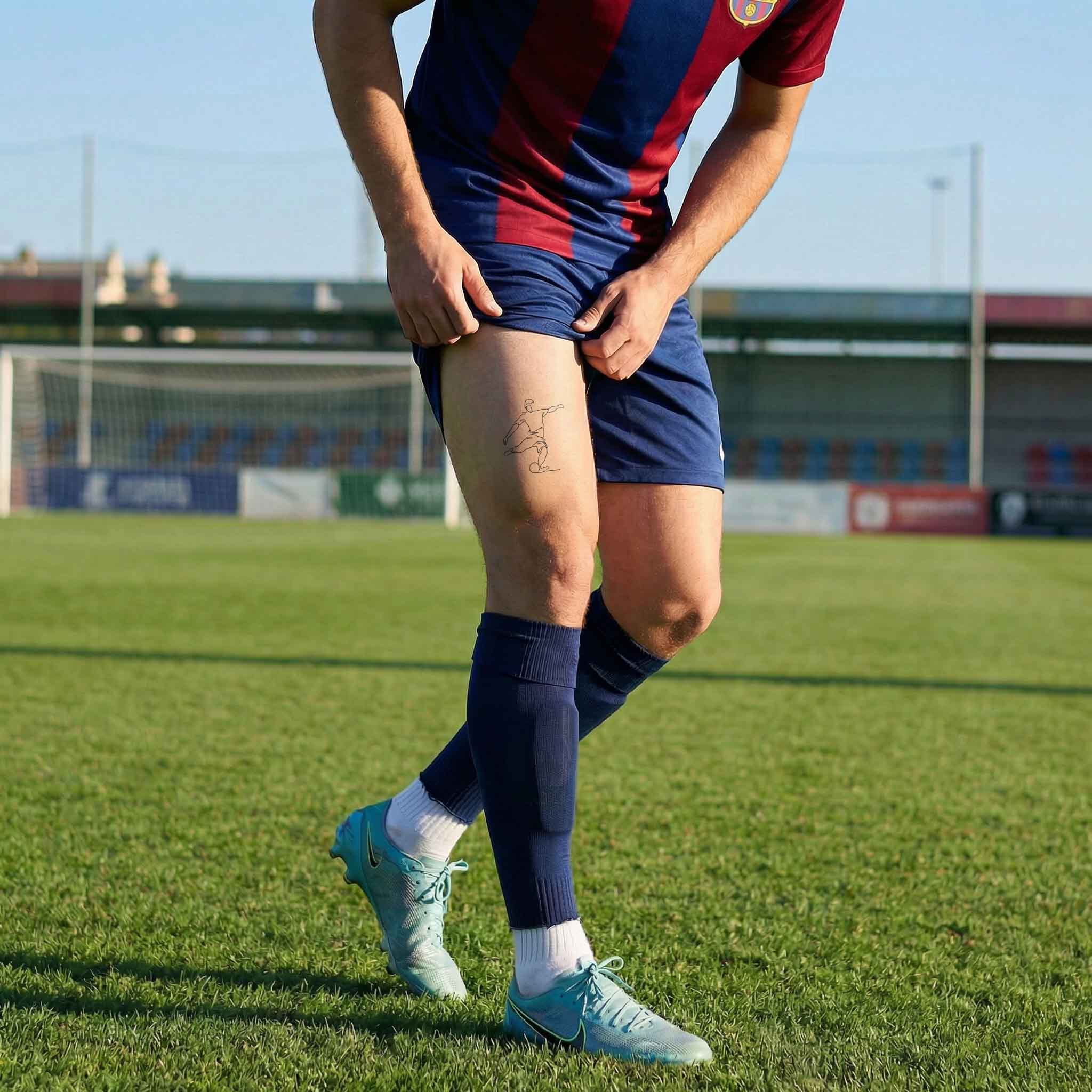 Fine line football strike tattoo placed on thigh with dynamic motion design