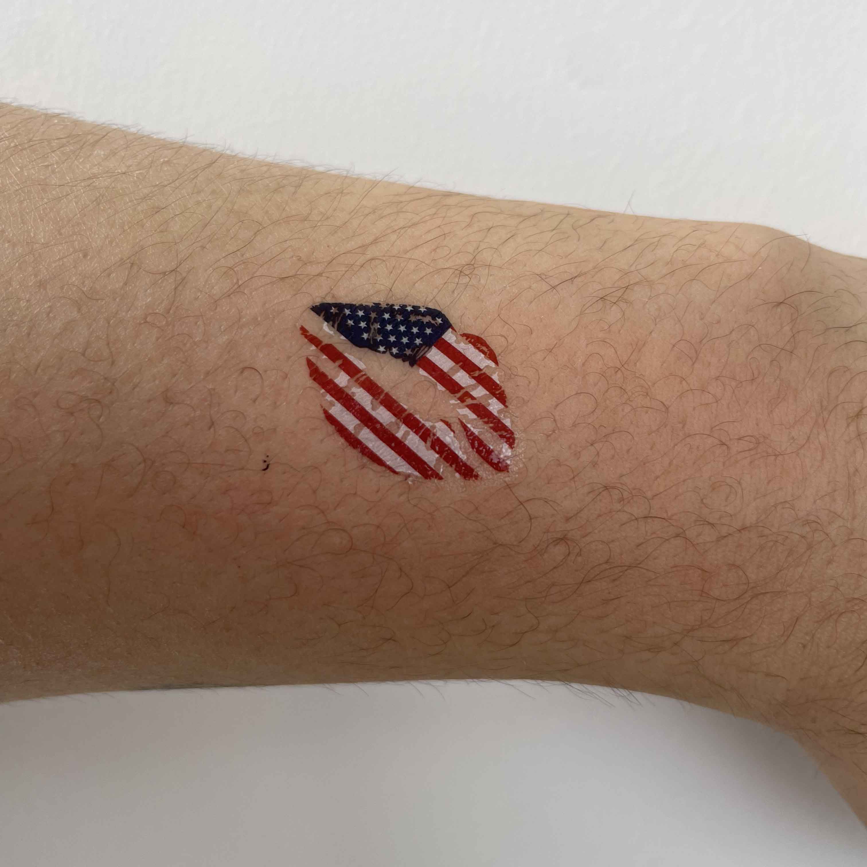 USA flag heart temporary tattoo worn on arm for football game day and patriotic fan outfit look