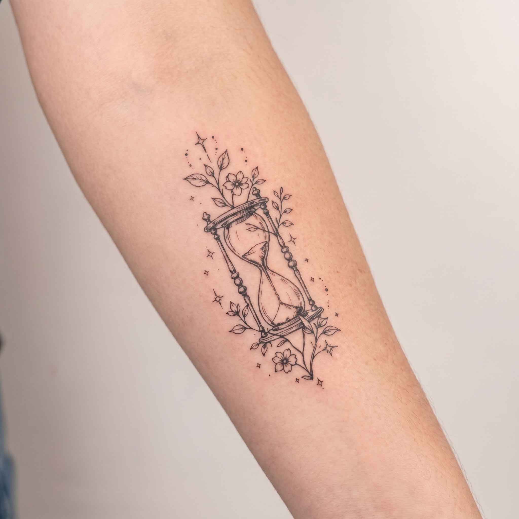 wearing hourglass flower 2 week temporary tattoo on forearm